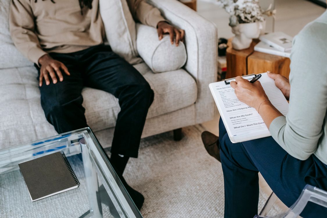 Profissional faz anotações durante uma consulta em saúde mental.