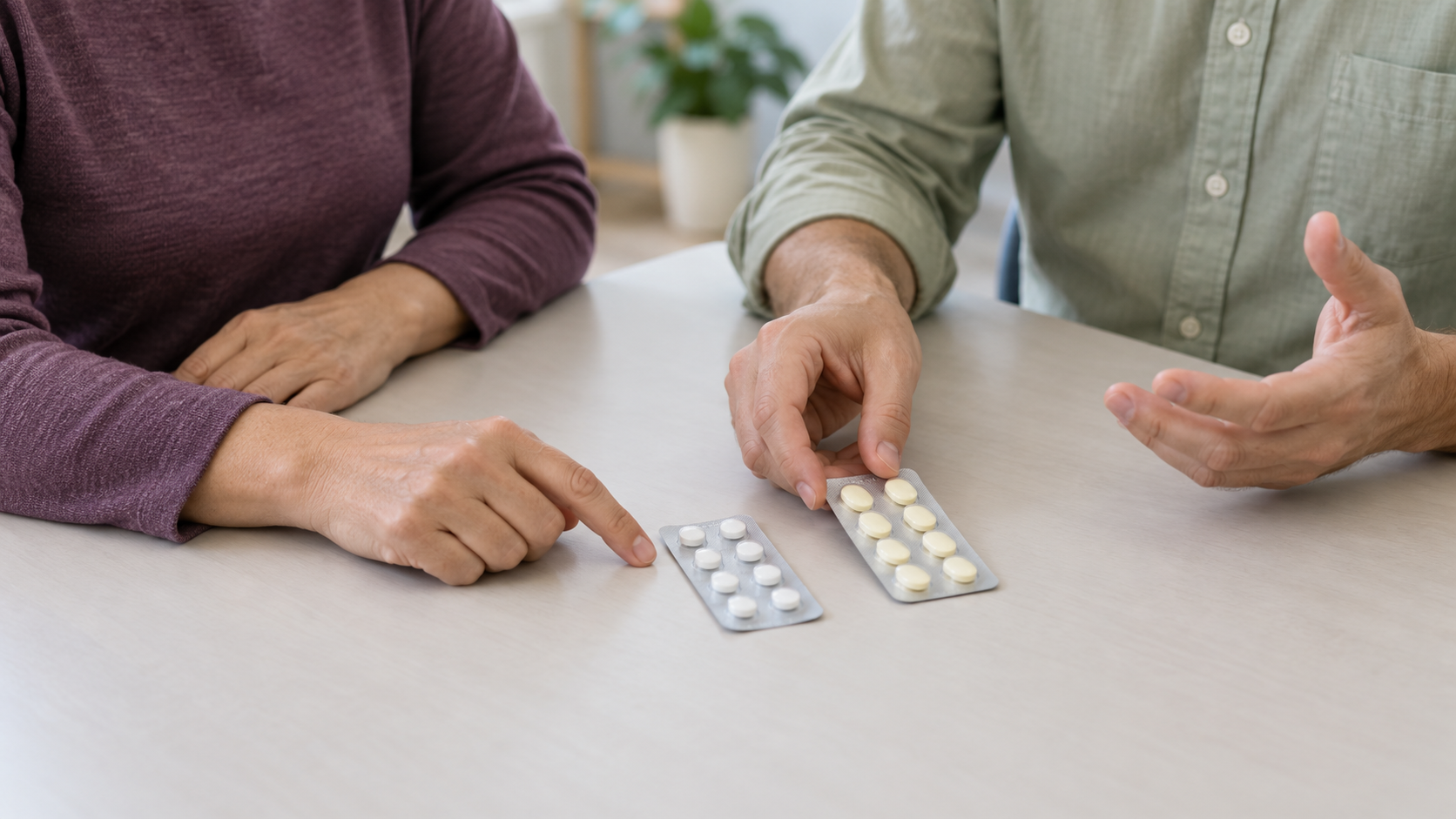 Duas pessoas apontam e aproximam duas cartelas de medicamentos sobre uma mesa.