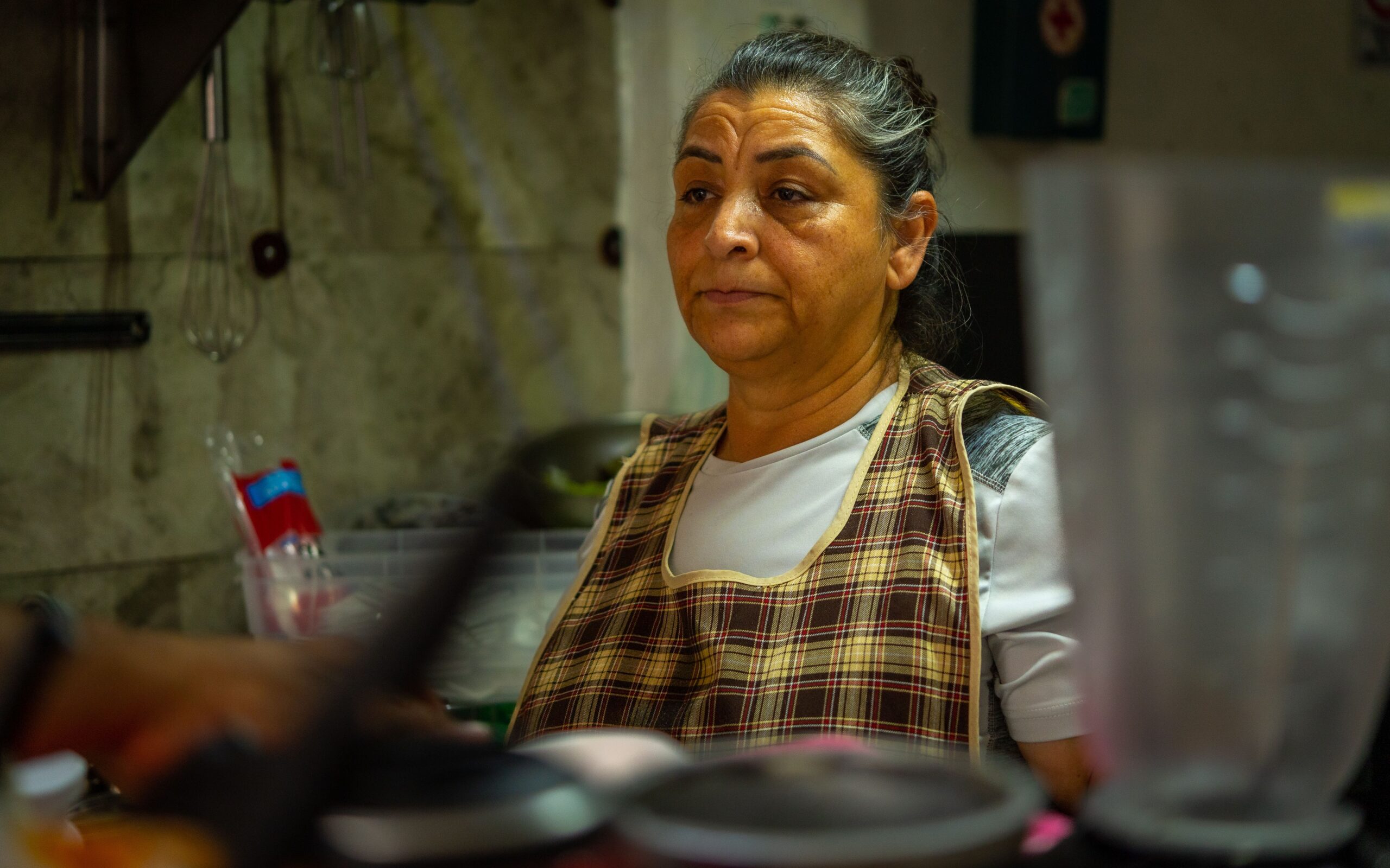 Mulher de avental em uma cozinha.