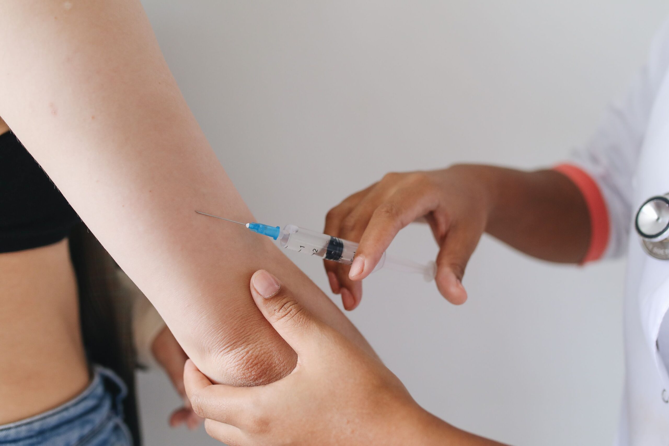 Profissional de saúde aplicando uma injeção no braço